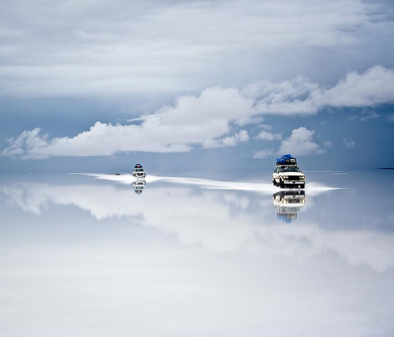 Tv bilar speglar sig i vrldens strsta saltken Salar de Uyuni..
