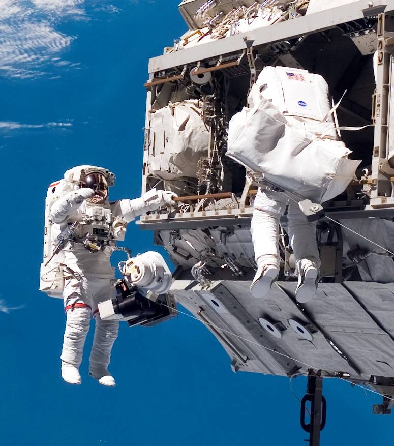 Christer Fuglesang och Robert Curbeam p rymdpromenad utanfr Internationella rymdstationen, med jorden i bakgrunden