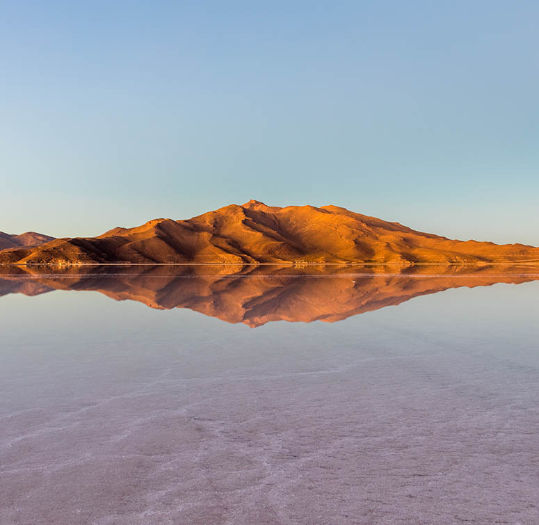 Berg speglar sig i vrldens strsta saltken Salar de Uyuni..