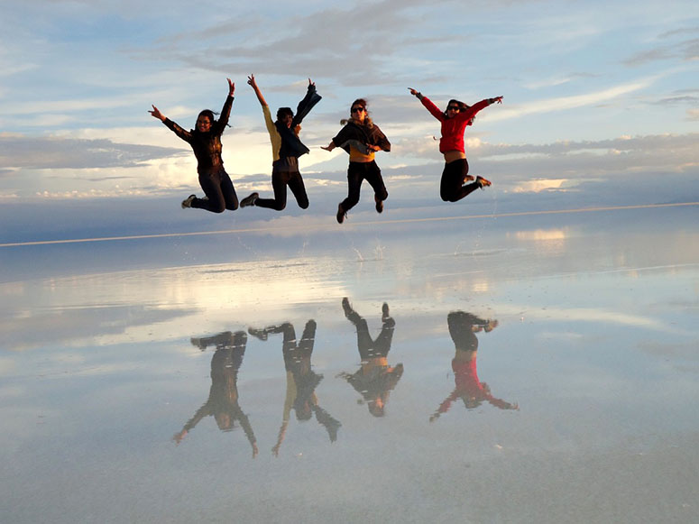 Mnniskor hoppar p Salar de Uyuni..