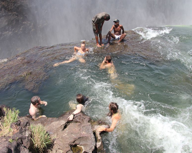 Människor som badar i Devil's Pool vid Victoriafallen