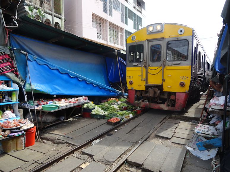 Tåg passerar genom marknaden i Mae Klong, Bangkok, Thailand