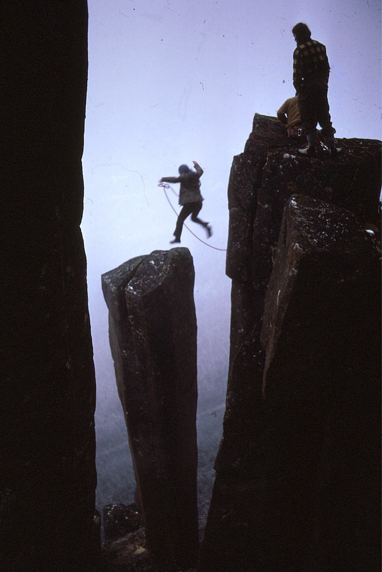 En klättrare hoppar till Albert's Tomb, en av stenpelarna på Mount Wellington.