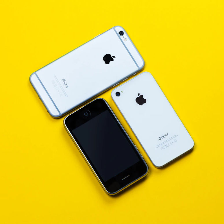 Tre iPhones mot en gul bakgrund