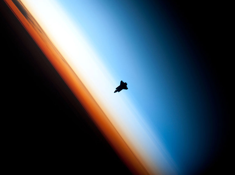 Siluetten av rymdfärjan Endeavour mot jordens atmosfär
